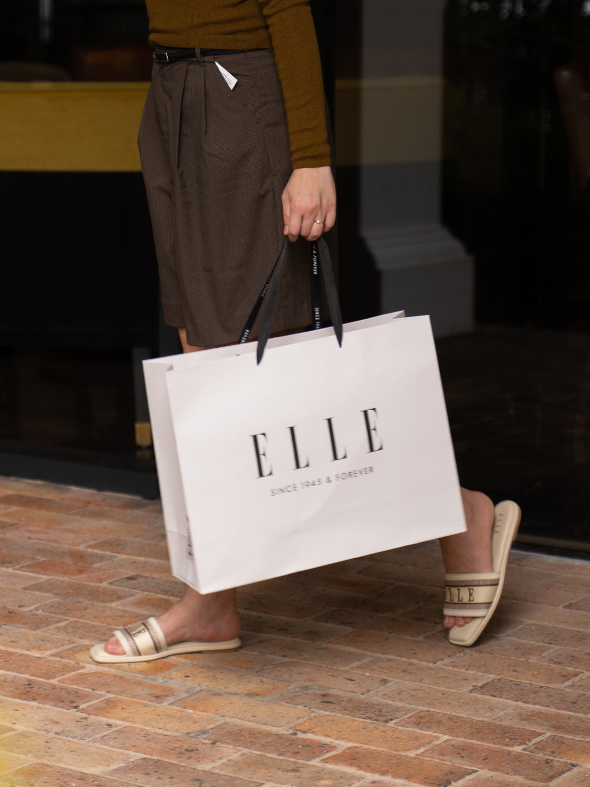 Woman carrying an ELLE shopping bag